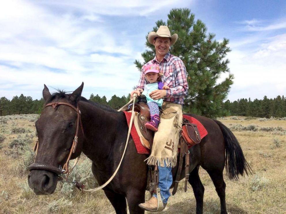 PHOTO: Jess Peterson rides a horse with his daughter on his cattle ranch east of Billings, Montana.