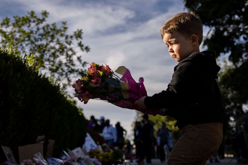 PHOTO: A young boy places flowers at a makeshift memorial in honor of Supreme Court Justice Ruth Bader Ginsburg at the U.S. Supreme Court on Sept. 19, 2020.