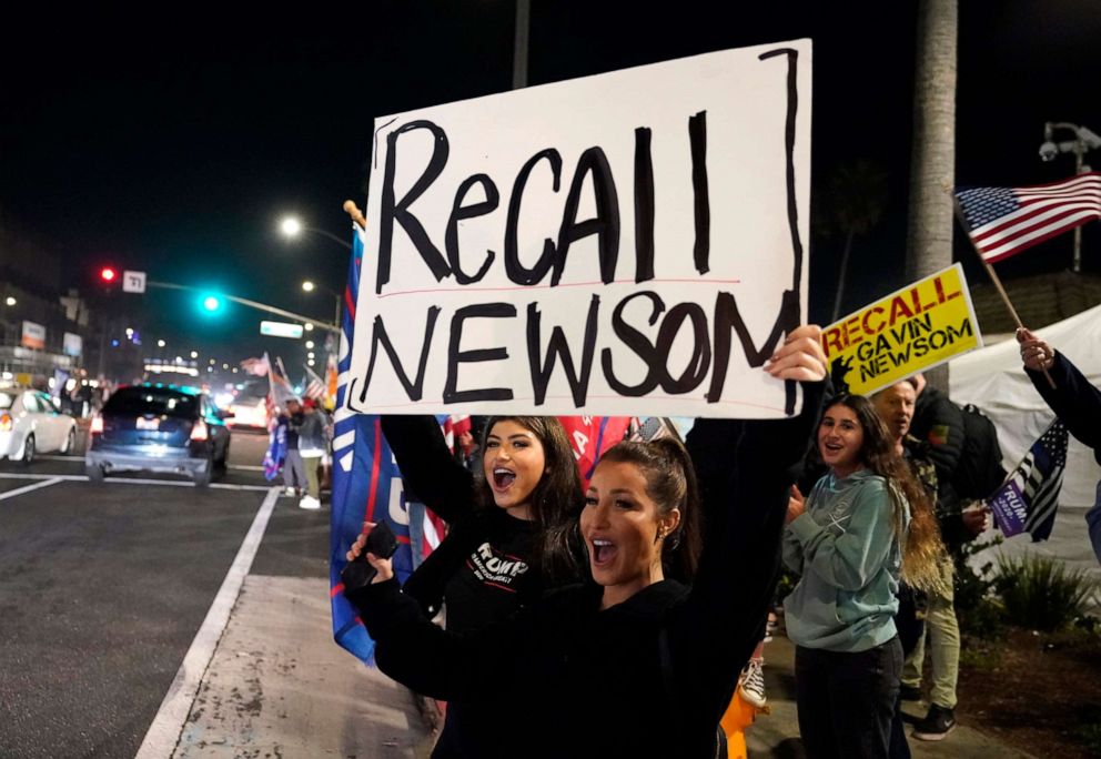 PHOTO: Trump supporters shout slogans while carrying a sign calling for a recall on California Gov. Gavin Newsom during a protest against a stay-at-home order amid the COVID-19 pandemic in Huntington Beach, Calif.