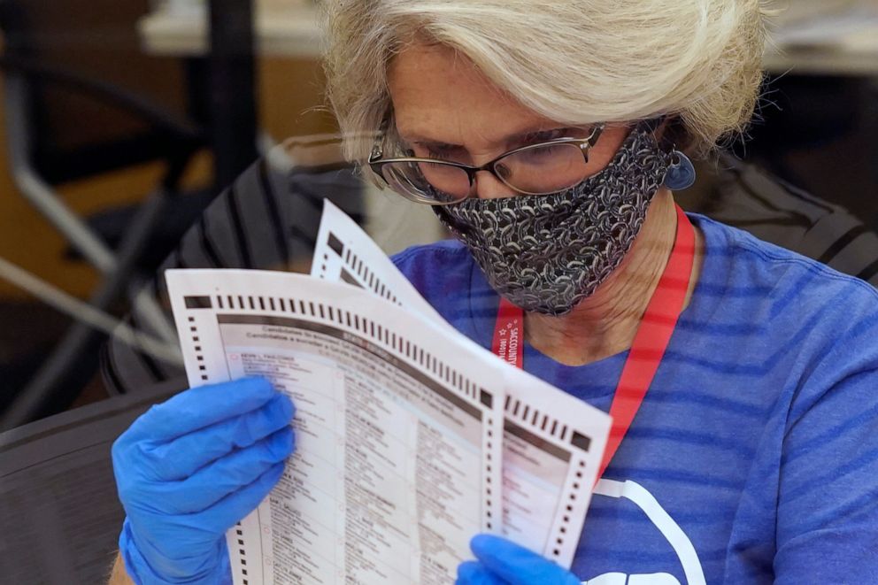 PHOTO: Gerri Kanelos inspects a ballot for damage before they are sent to be tabulated at the Sacramento County Registrar of Voters Office in Sacramento, Calif., Tuesday, Sept. 14, 2021.