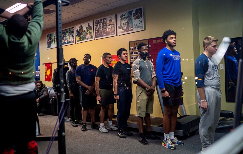 PHOTO: Men who have signed up to join the U.S. Marines stand in line to do qualifying pull-ups at recruiting station Nov. 16, 2021 in New York City.