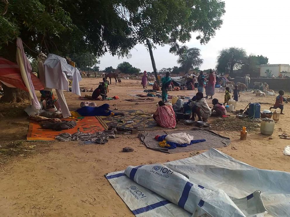 In this July 30, 2020 file photo, residents displaced from a surge of violent attacks squat on blankets and in hastily made tents in the village of Masteri in west Darfur, Sudan. 