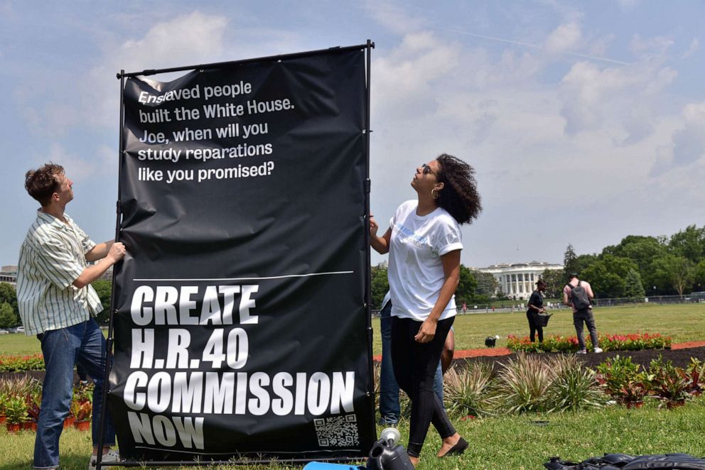 PHOTO: Reparations activists outside new art installation calling on President Joe Biden to sign an executive order on reparations in Washington.
