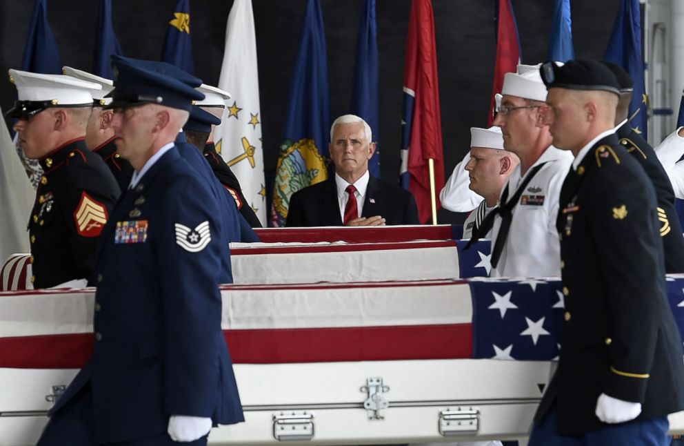 PHOTO: United States Vice President Mike Pence (L) pays respects as a military honor guard carries the remains of american soldiers repatriated from North Korea after arriving to Joint Base Pearl Harbor-Hickam, Honolulu, Hawaii, Aug. 1, 2018. 

