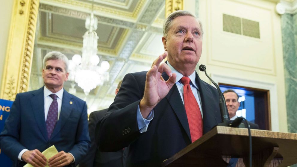 Republican Senator from South Carolina Lindsey Graham (R) speaks in front of Republican Senator from Louisiana Bill Cassidy (L) during a news conference held to introduce healthcare legislation on Capitol Hill, Sept. 13, 2017.