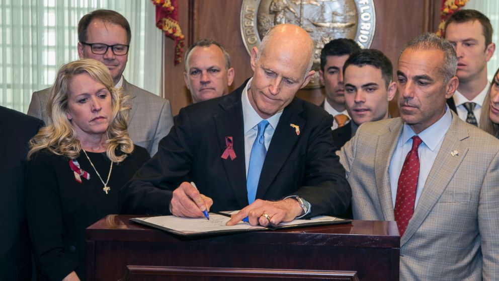 Florida Gov. Rick Scott signs Marjory Stoneman Douglas Public Safety Act in the Governor's office in Tallahassee, Fla., March 9, 2018.