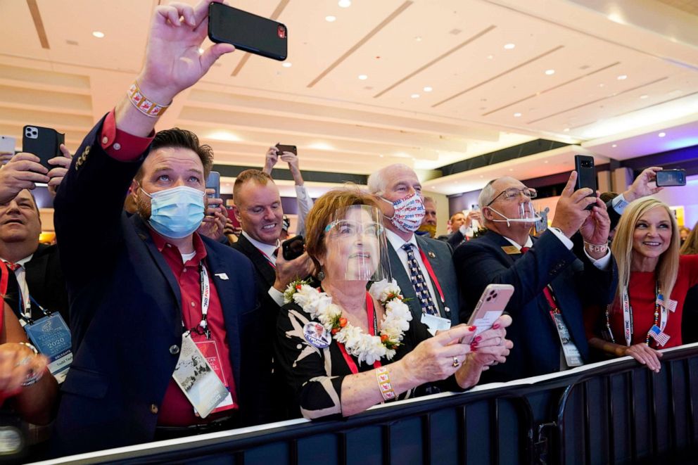 PHOTO: People listen as President Donald Trump speaks on stage as he visits the Republican National Committee convention site, Aug. 24, 2020, in Charlotte. 