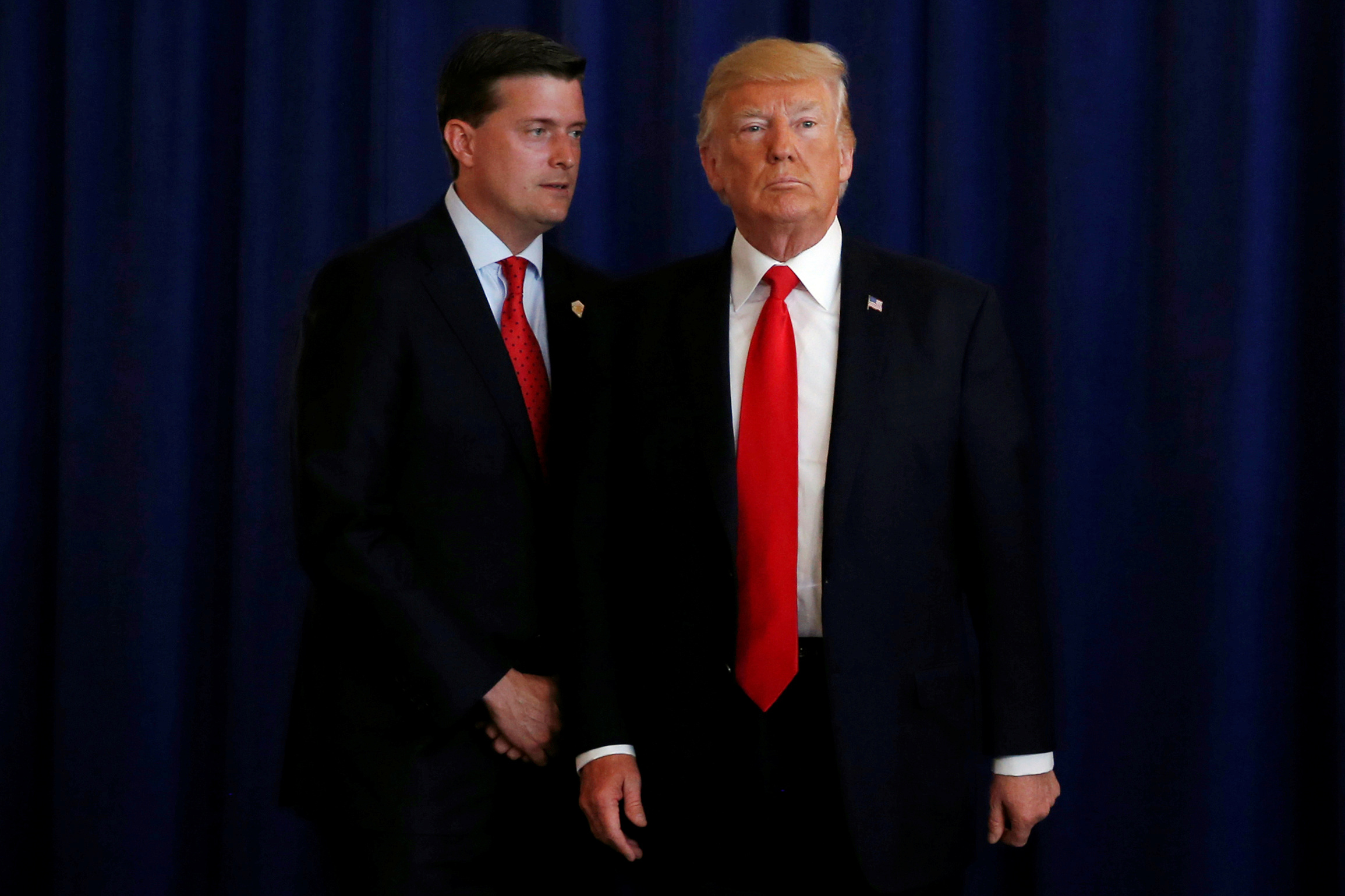 PHOTO: White House Staff Secretary Rob Porter (L) reminds President Donald Trump he had a bill to sign after he departed quickly following remarks at his golf estate in Bedminster, N.J., Aug. 12, 2017.