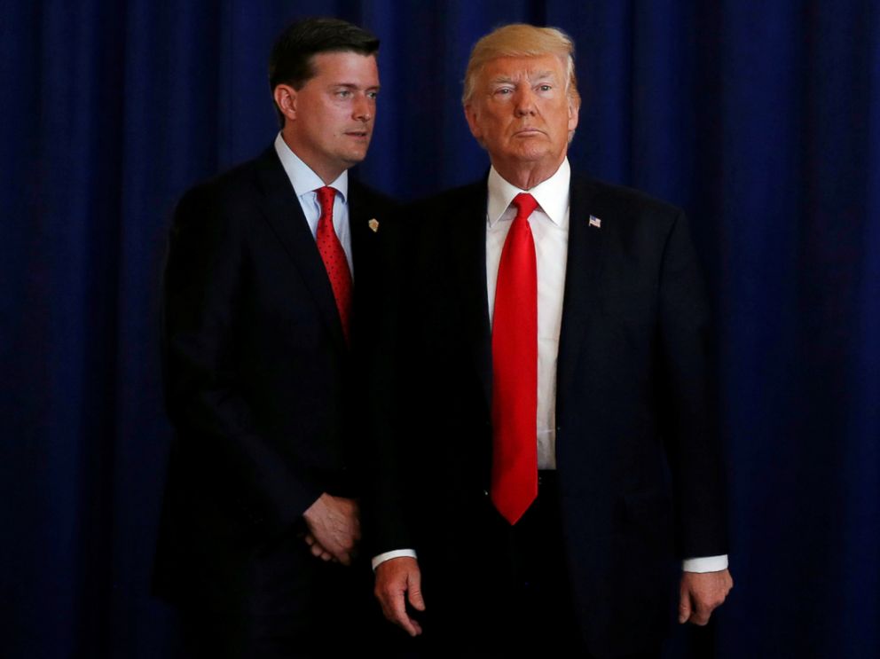 PHOTO: White House Staff Secretary Rob Porter (L) reminds President Donald Trump he had a bill to sign after he departed quickly following remarks at his golf estate in Bedminster, N.J., Aug. 12, 2017.