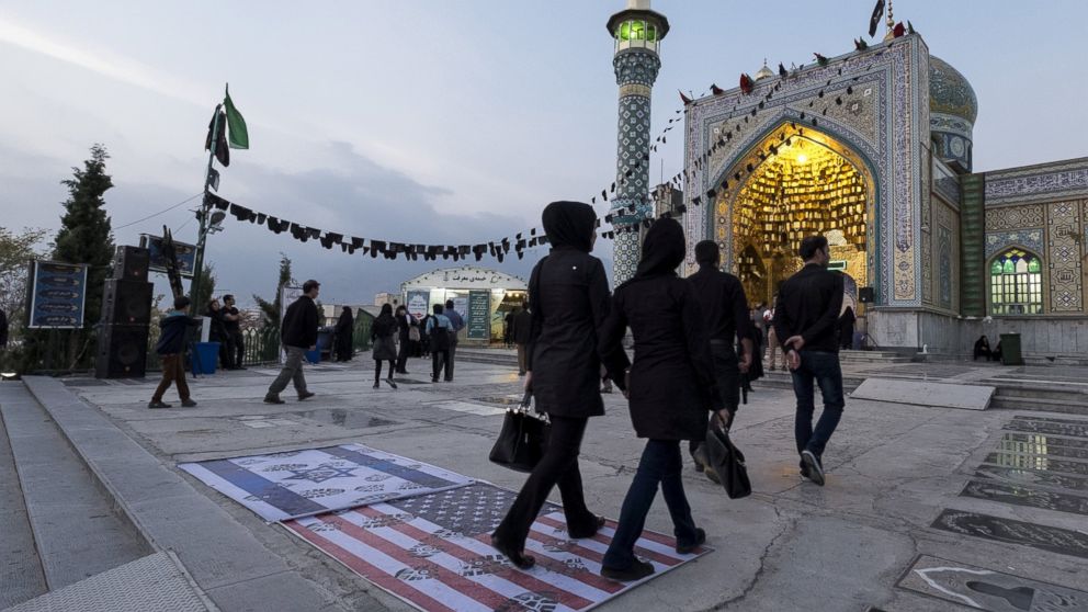 People step on a US flag and an Israeli flag at a shrine on Ashura in the north of Tehran Oct. 24, 2015.