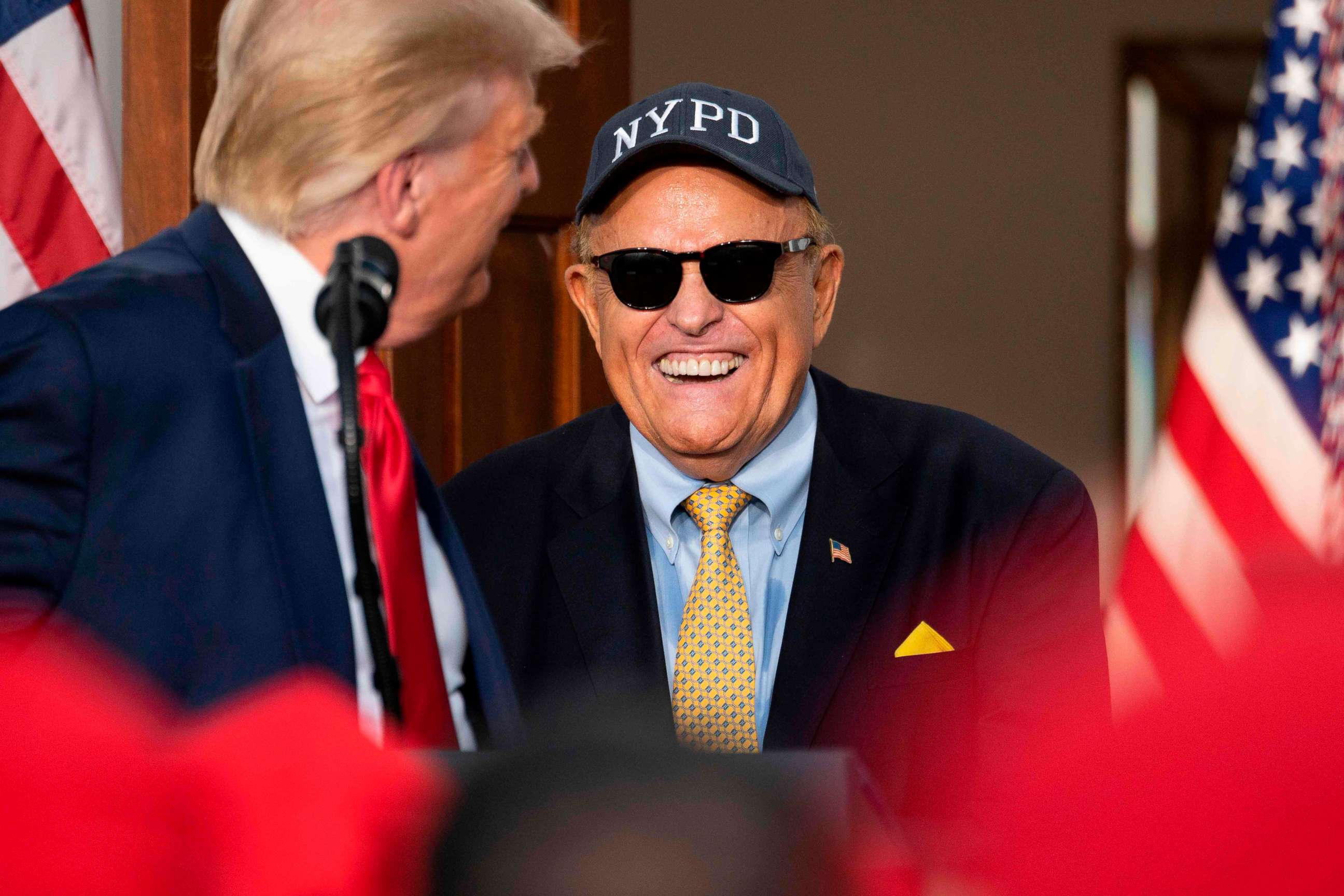 PHOTO: President Donald Trump's personal lawyer Rudy Giuliani smiles to Trump after he delivers remarks to the City of New York Police Benevolent Association at the Trump National Golf Club in Bedminster, N.J., on Aug. 14, 2020.