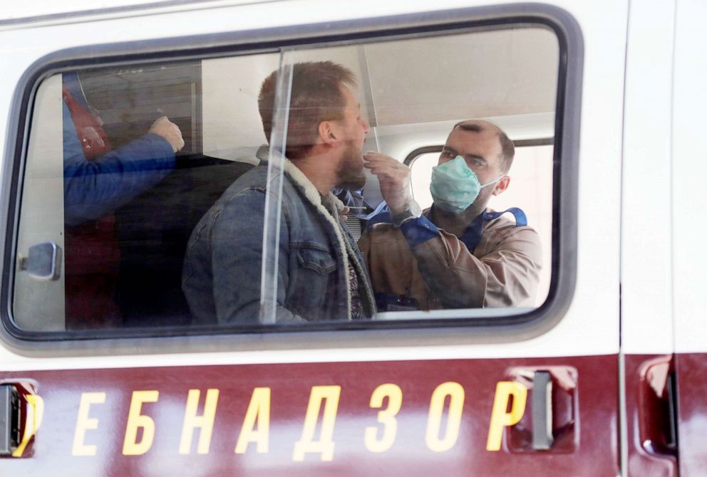 PHOTO: A medic wearing a protective mask takes a swab from a man inside a mobile laboratory for coronavirus testing near Saint Petersburg's Pulkovo Airport, Russia March 23, 2020.