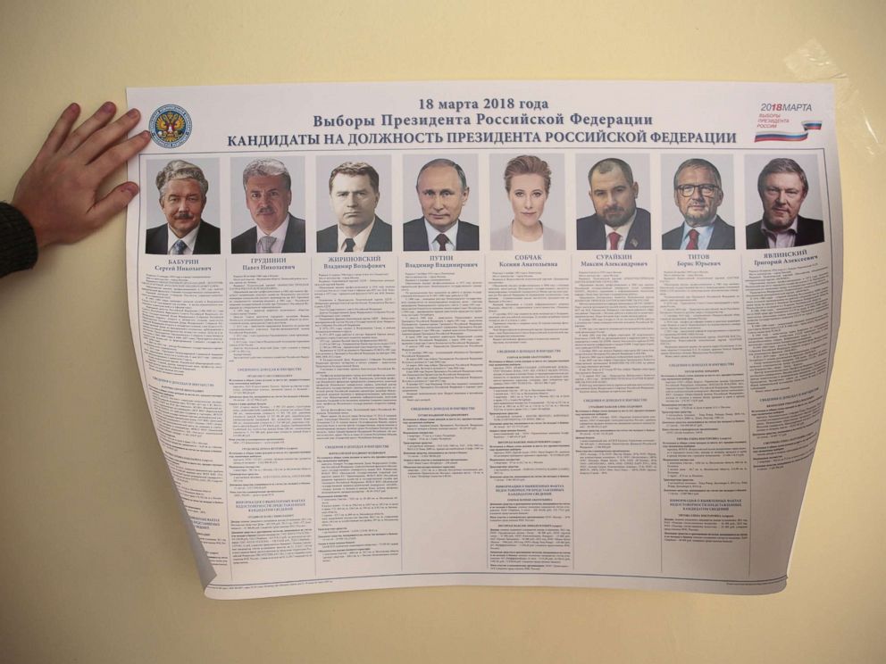 PHOTO: A member of a local electoral commission attaches a broadsheet with information about the candidates during preparations for the upcoming presidential election at a polling station in St. Petersburg, March 17, 2018.