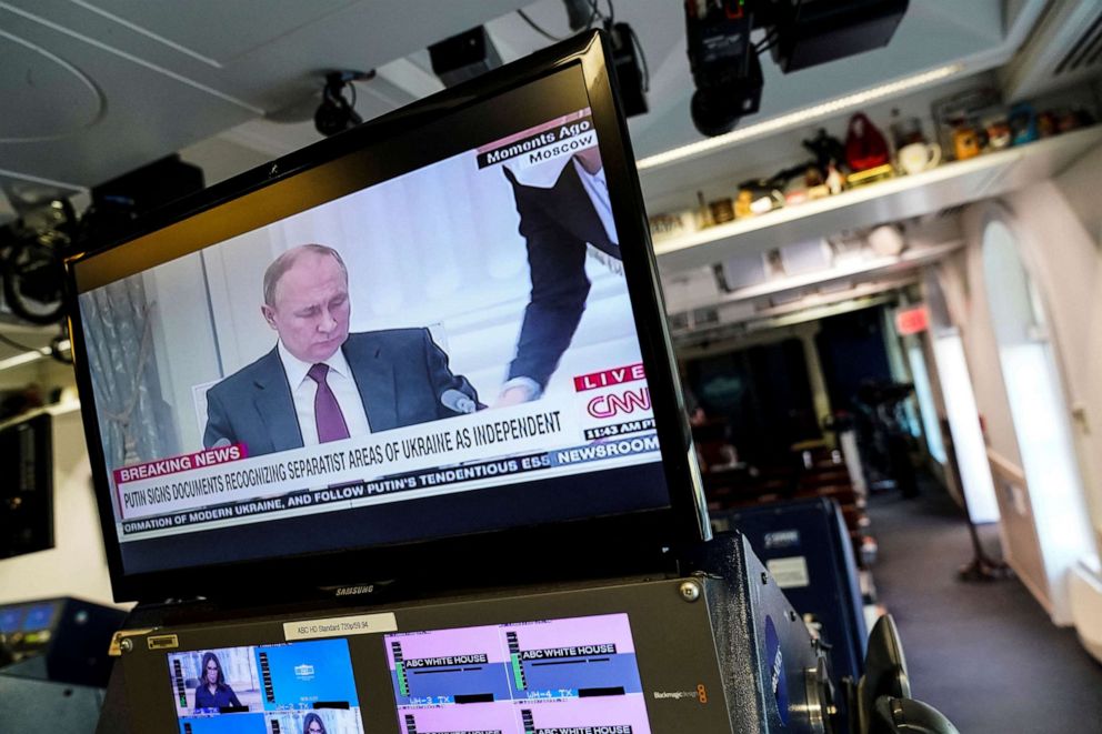 PHOTO: Russian President Vladimir Putin appears on a screen at the White House briefing room during a TV broadcast, signing documents recognizing separatist areas of Ukraine as independent, in Washington Feb, 21, 2022.