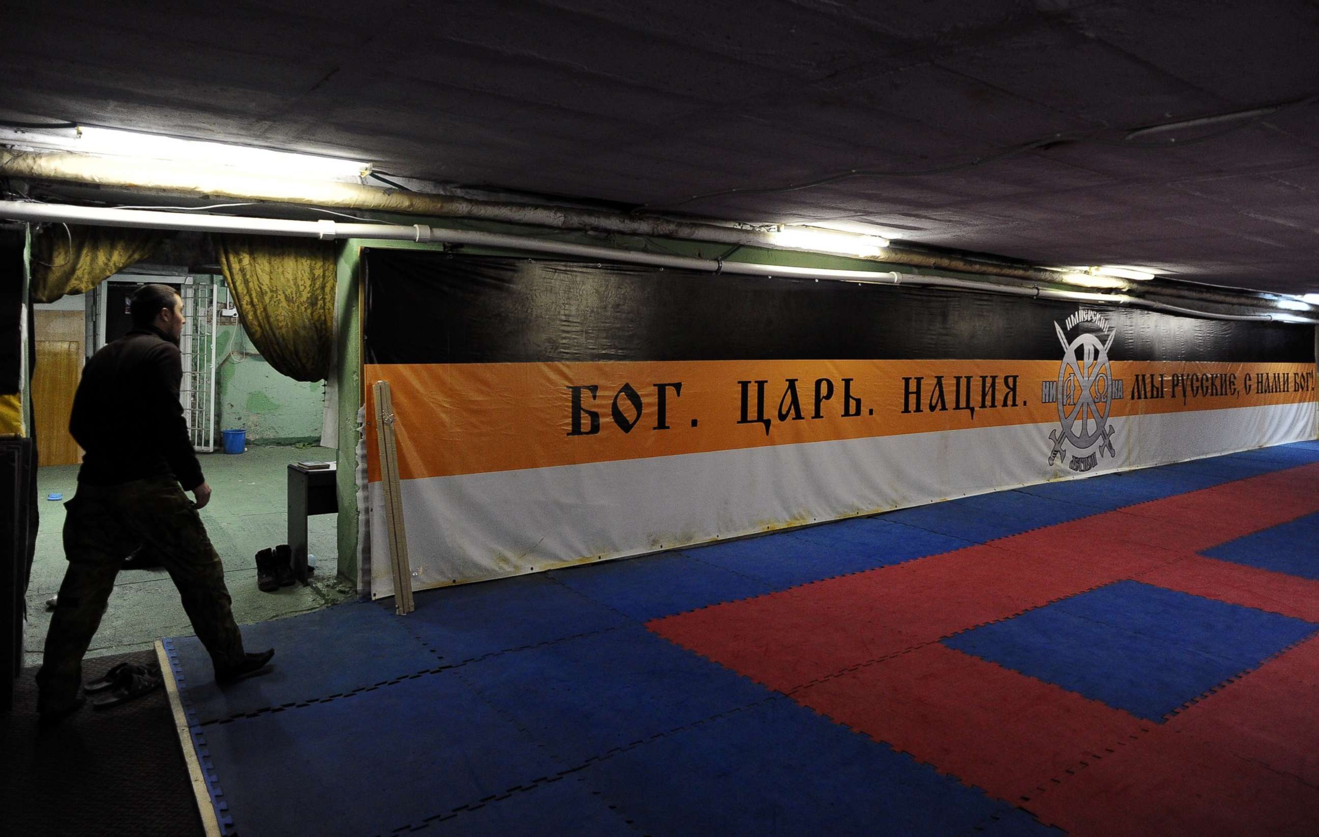 PHOTO: In this February 28, 2015, file photo, a member of the Russian Imperial Movement, a nationalist group in Russia, walks close to a banner reading "God.Tsar.Nation.We are Russians, God with us" at a training base in Saint-Petersburg.