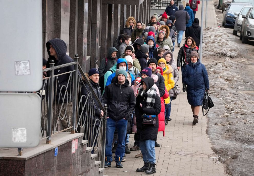 PHOTO: People stand in line to withdraw U.S. dollars and Euros from an ATM in St. Petersburg, Russia, Feb. 25, 2022.