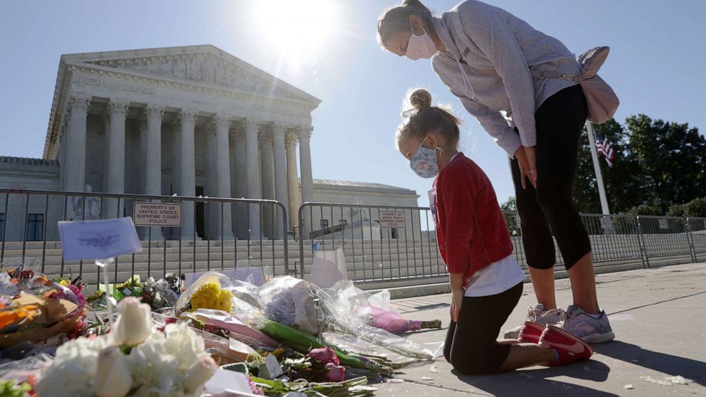 PHOTO: Abby Martin of Arlington, Va., pays respect with her mother Jackie Martin as they visit a makeshift memorial in front of the U.S. Supreme Court for the late Justice Ruth Bader Ginsburg in Washington,  Sept. 21, 2020.