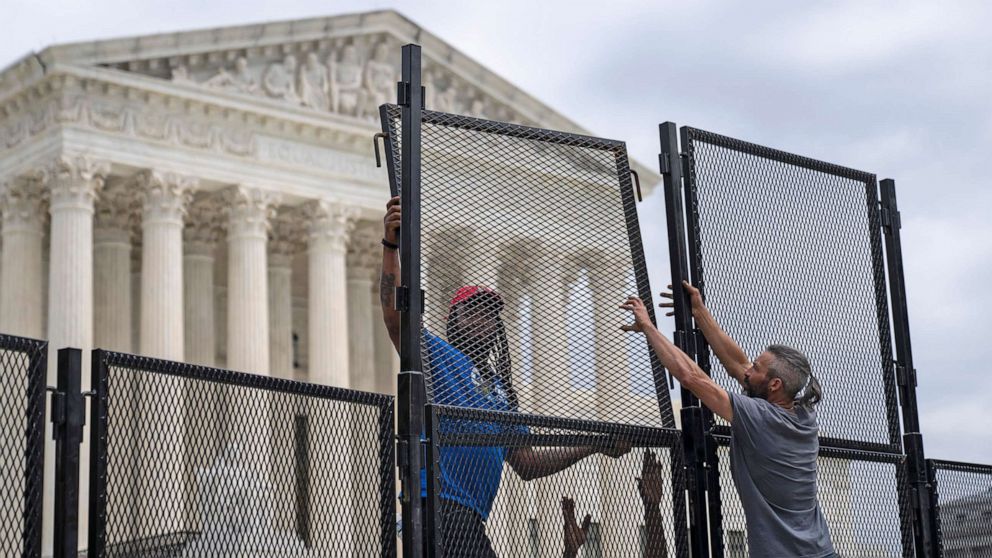 PHOTO: Workers add additional height to the security fencing surrounding the U.S. Supreme Court on May 11, 2022 in Washington, D.C. 