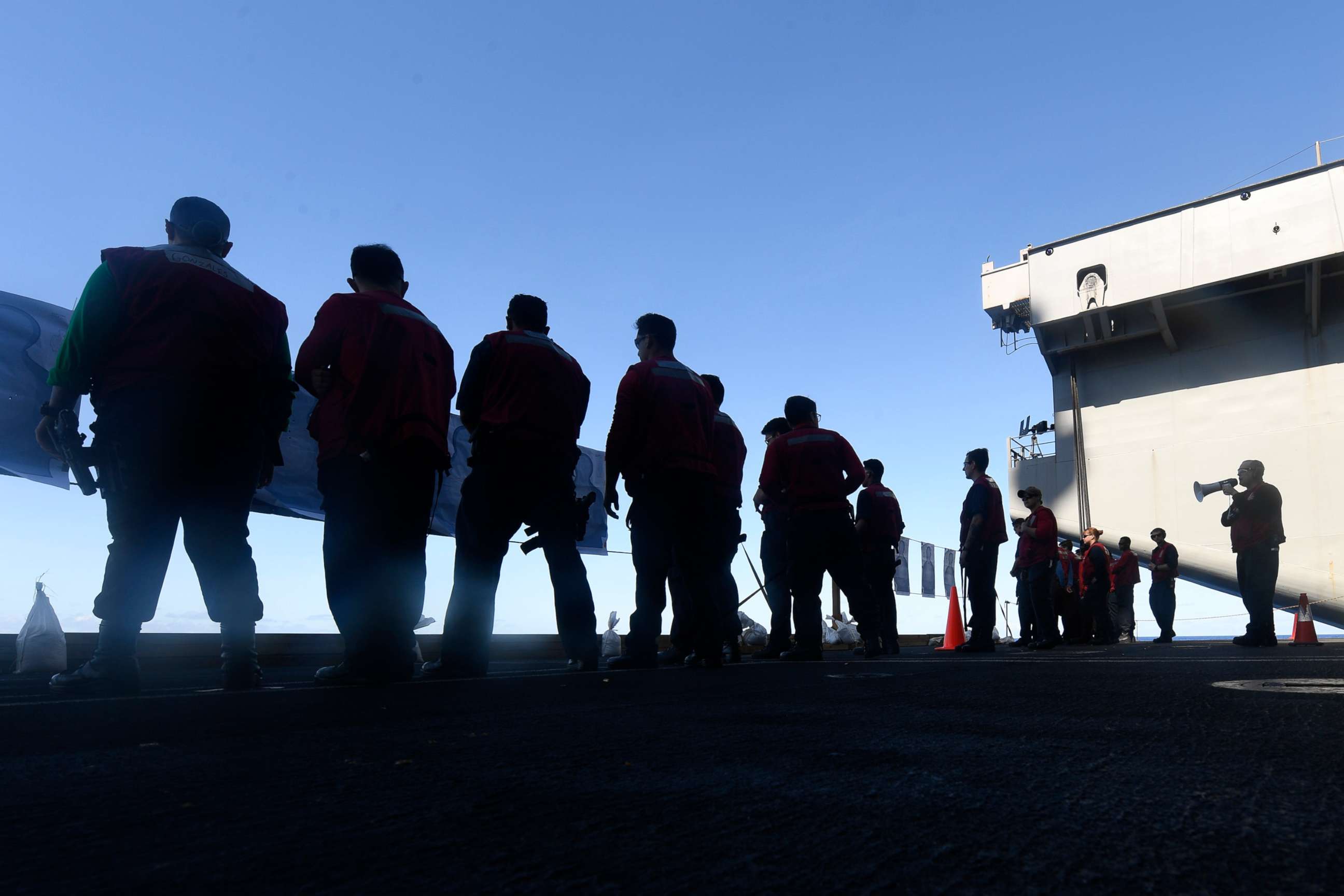 PHOTO: U.S. Sailors stand aboard the aircraft carrier USS Theodore Roosevelt (CVN 71) March 22, 2020.