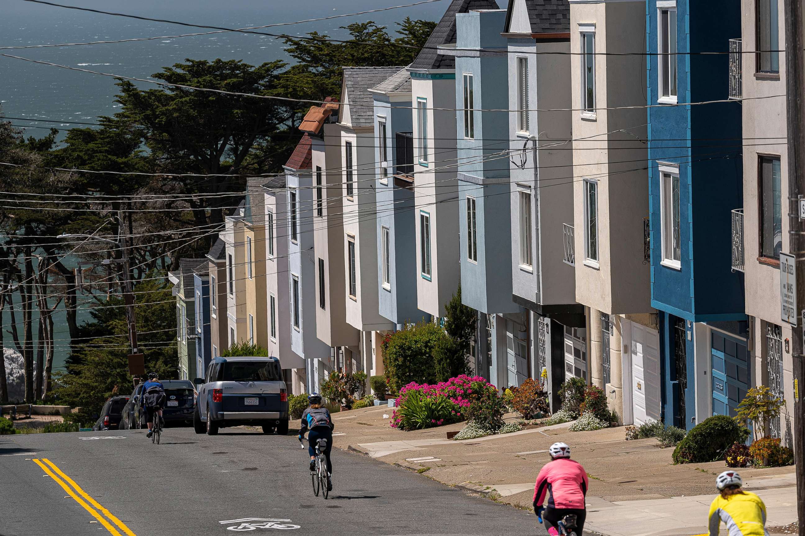 PHOTO: Cyclists ride past residential housing in San Francisco, April 9, 2021. 