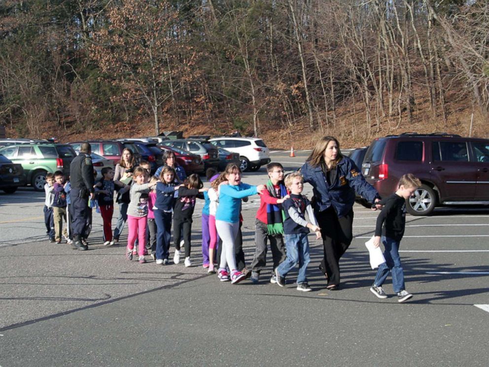 PHOTO: Two Connecticut State police officers accompany a class of students, and two adults, out of Sandy Hook Elementary School, Dec. 14, 2012. A gunman entered the building and fatally shot 20 children and six adults before taking his own life.