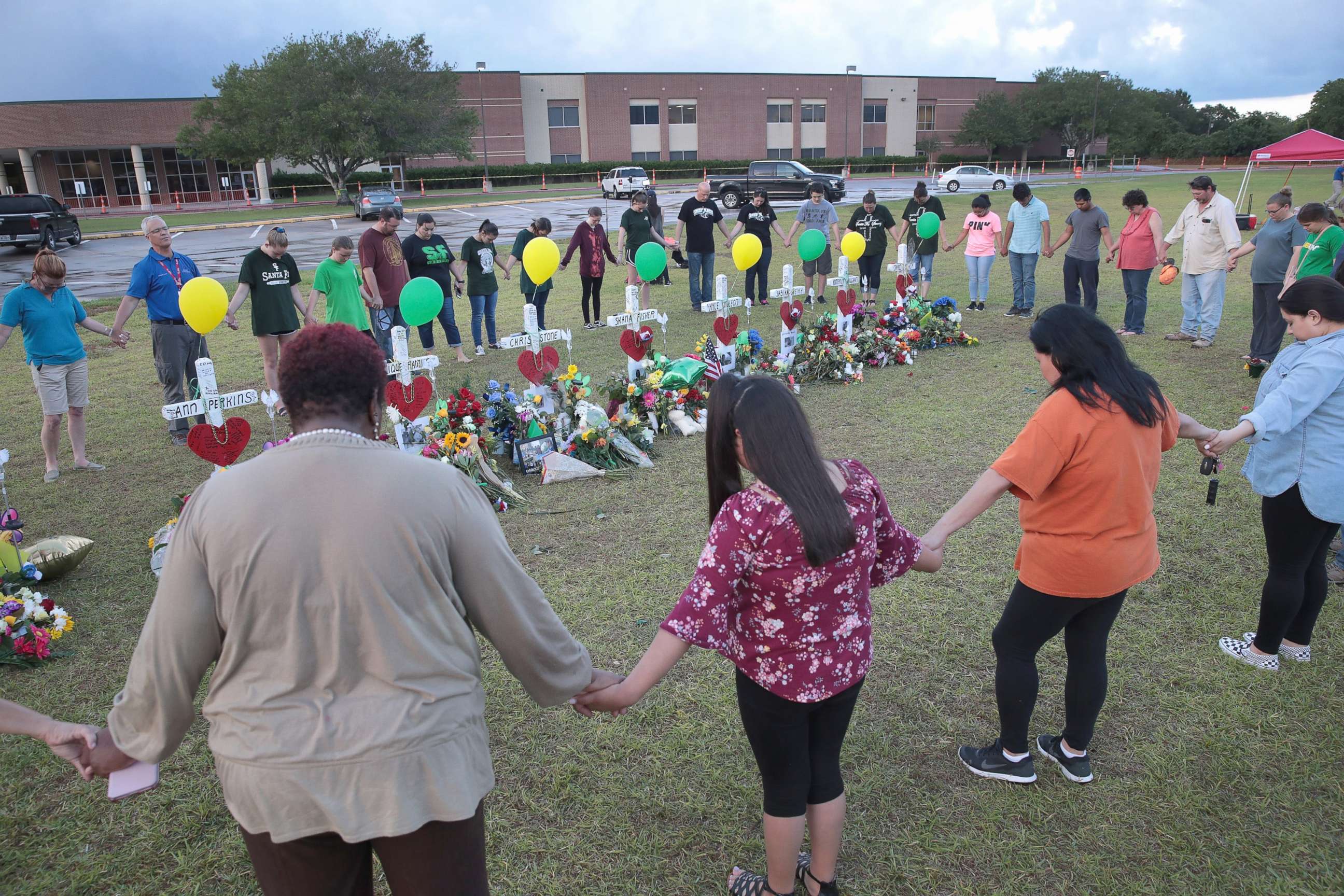 PHOTO: Mourners pray around a memorial in front of Santa Fe High School, May 21, 2018, in Santa Fe, Texas.