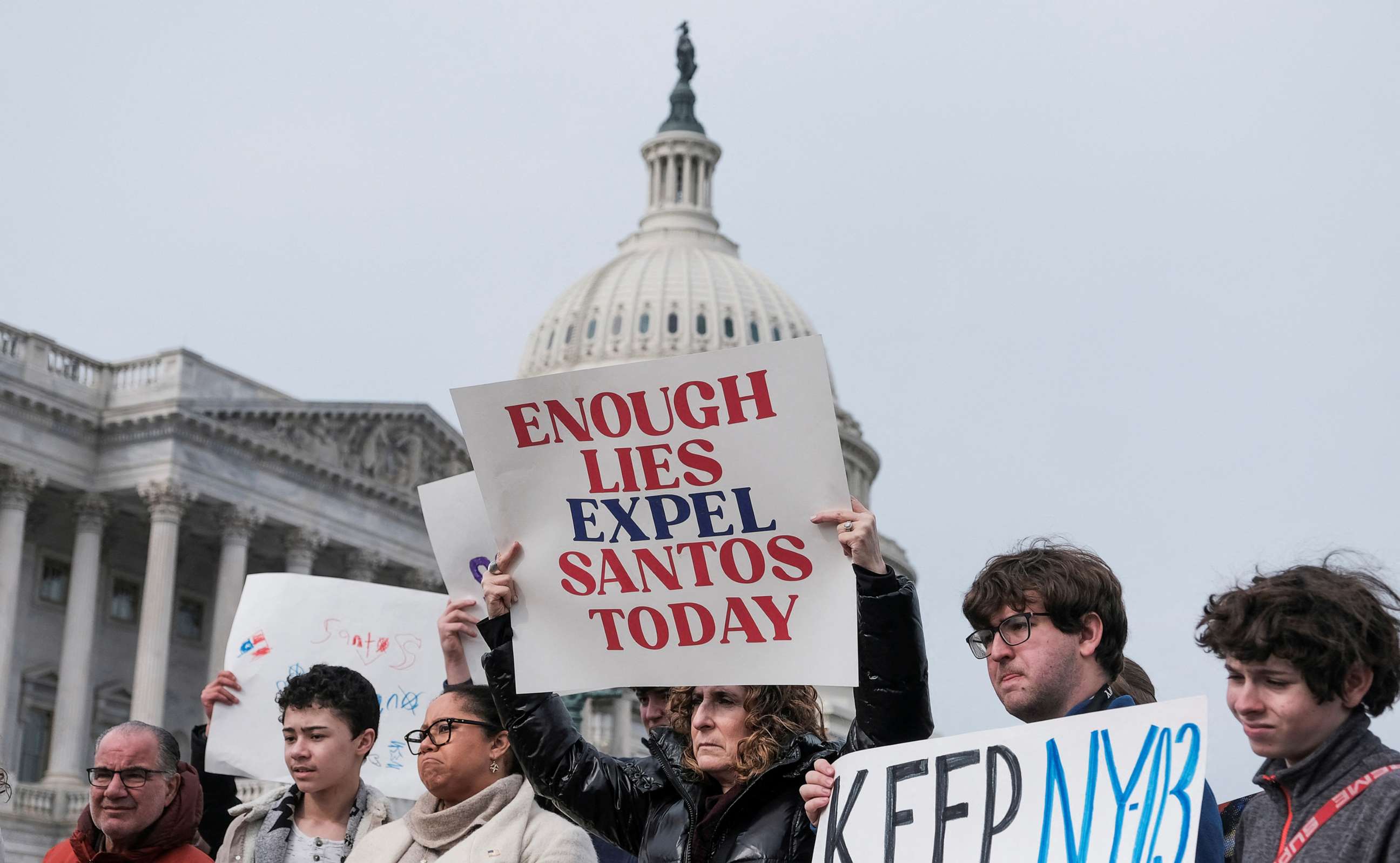 PHOTO: People hold banners on the day of a news conference calling for the resignation of Santos held by Rep. Dan Goldman, Rep. Ritchie Torres, and a group of Rep. George Santos's constituents at the Capitol, Feb. 7, 2023.