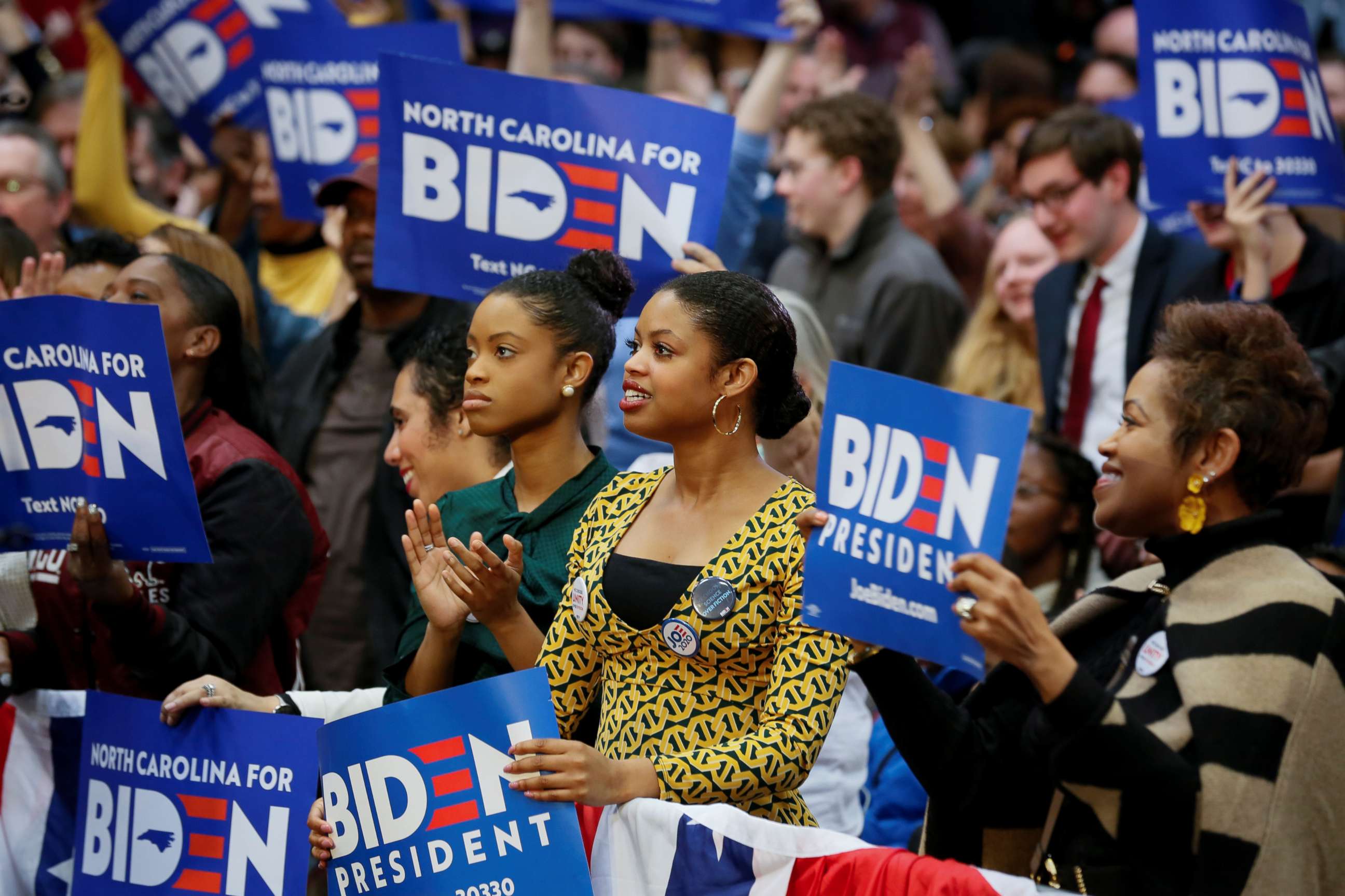PHOTO: People wave campaign signs during an event with Democratic presidential candidate and former U.S. Vice President Joe Biden at Saint Augustine's University in Raleigh, N.C., Feb. 29, 2020.