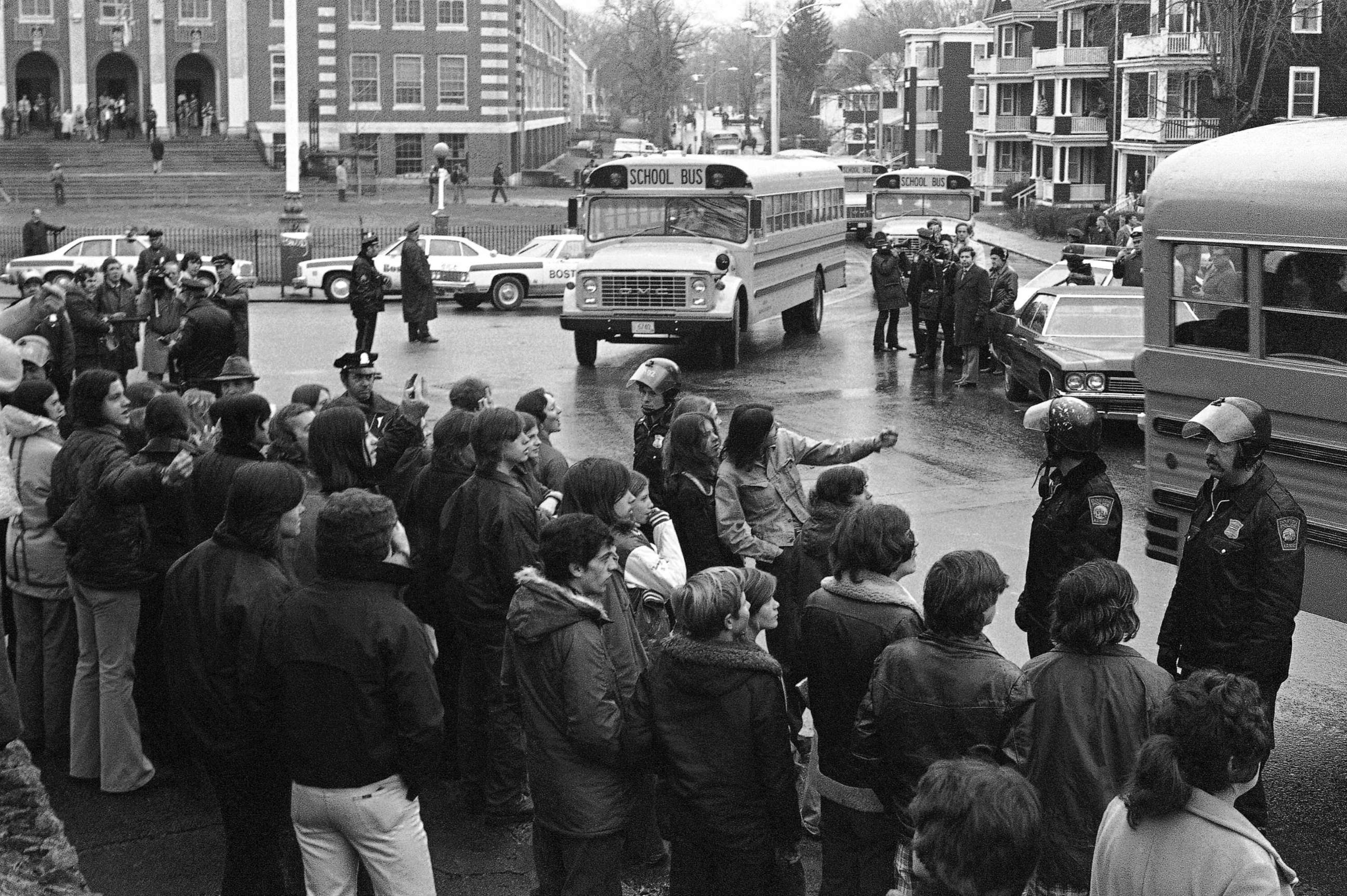 PHOTO: White students, who walked out of Boston's Hyde Park High School, stand along the curb and jeer school buses carrying blacks home from the school, Dec. 12, 1974.