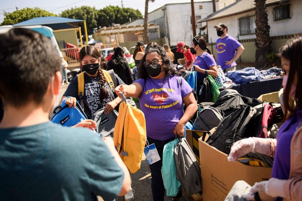 Nurses and health care workers with the Service Employees International Union distribute backpacks to children during a back-to-school event offering school supplies, COVID-19 vaccinations, face masks and other resourcesin Los Angeles on Aug. 7, 2021. 