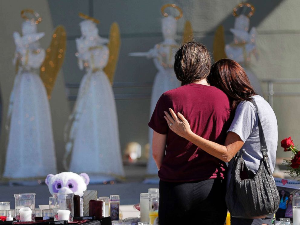 PHOTO: People comfort each other at a public memorial for the victims of the shooting at Marjory Stoneman Douglas High School, in Parkland, Fla., Feb. 16, 2018.