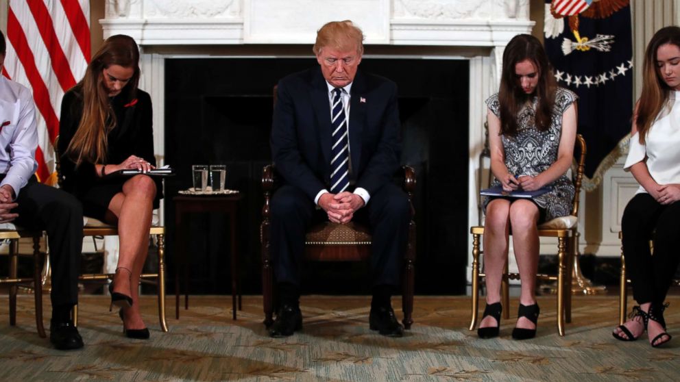 President Donald Trump bows his head during an opening prayer at the start of a listening session with high school students and teachers in the State Dining Room of the White House in Washington, Feb. 21, 2018.