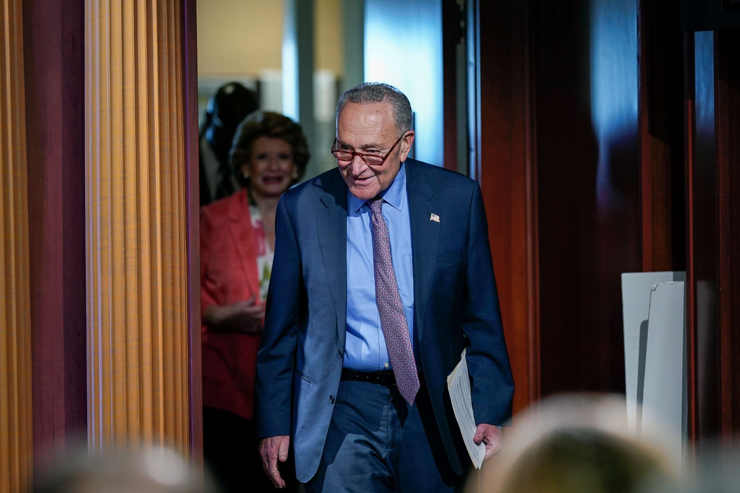 PHOTO: Senate Majority Leader Chuck Schumer followed by Sen. Debbie Stabenow, arrives to speak to reporters, July 26, 2022, at the Capitol in Washington, D.C.