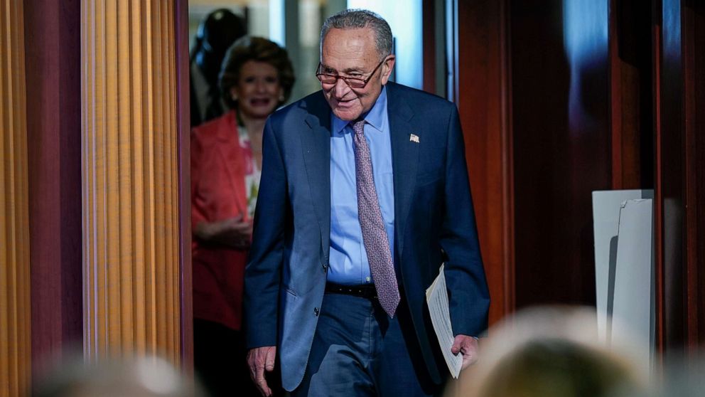 PHOTO: Senate Majority Leader Chuck Schumer followed by Sen. Debbie Stabenow, arrives to speak to reporters, July 26, 2022, at the Capitol in Washington, D.C.