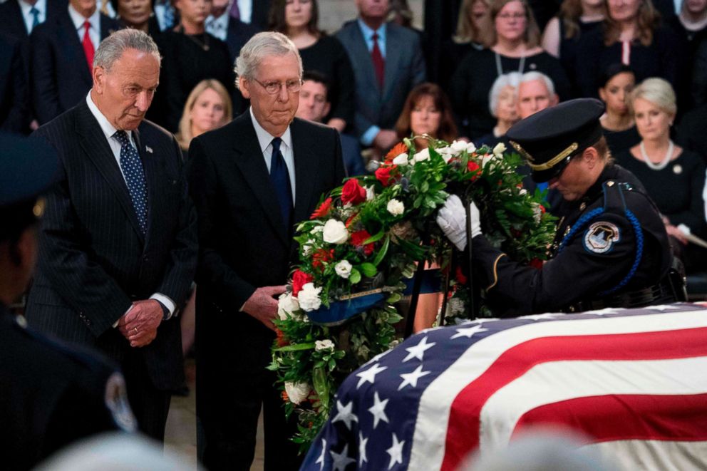 PHOTO: Senate Minority Leader Chuck Schumer and Senate Majority Leader Mitch McConnell of Kentucky watch as a wreath is placed at the casket of the late US Senator John McCain as he lies in state in the Rotunda of the Capitol, Aug. 31, 2018 in Washington.