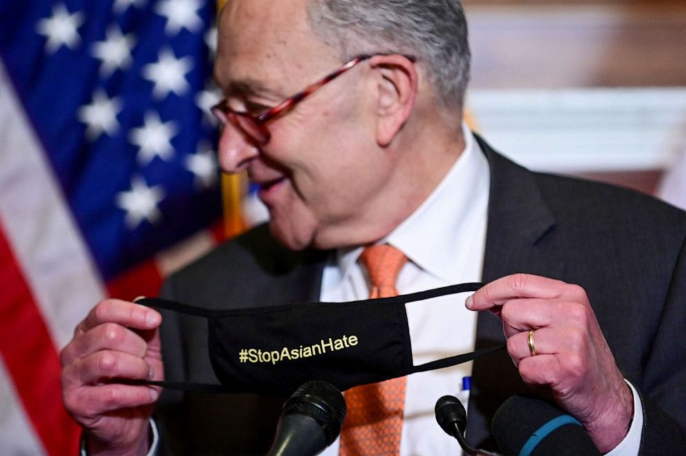 Senate Majority Leader Chuck Schumer displays his "#StopAsianHate" mask at a news conference after the Senate passed the COVID-19 Hate Crimes Act on April 22, 2021. 