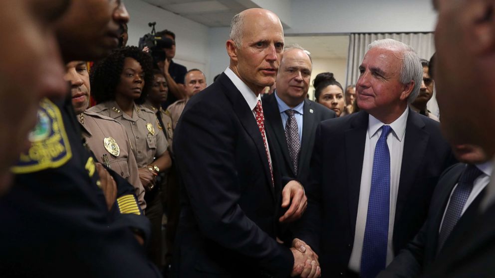 Florida Governor Rick Scott shakes hands with Miami-Dade Mayor Carlos A. Gimenez before speaking to the media about his plan to make changes to help keep Florida students safe, Feb. 27, 2018, in Doral, Fla.