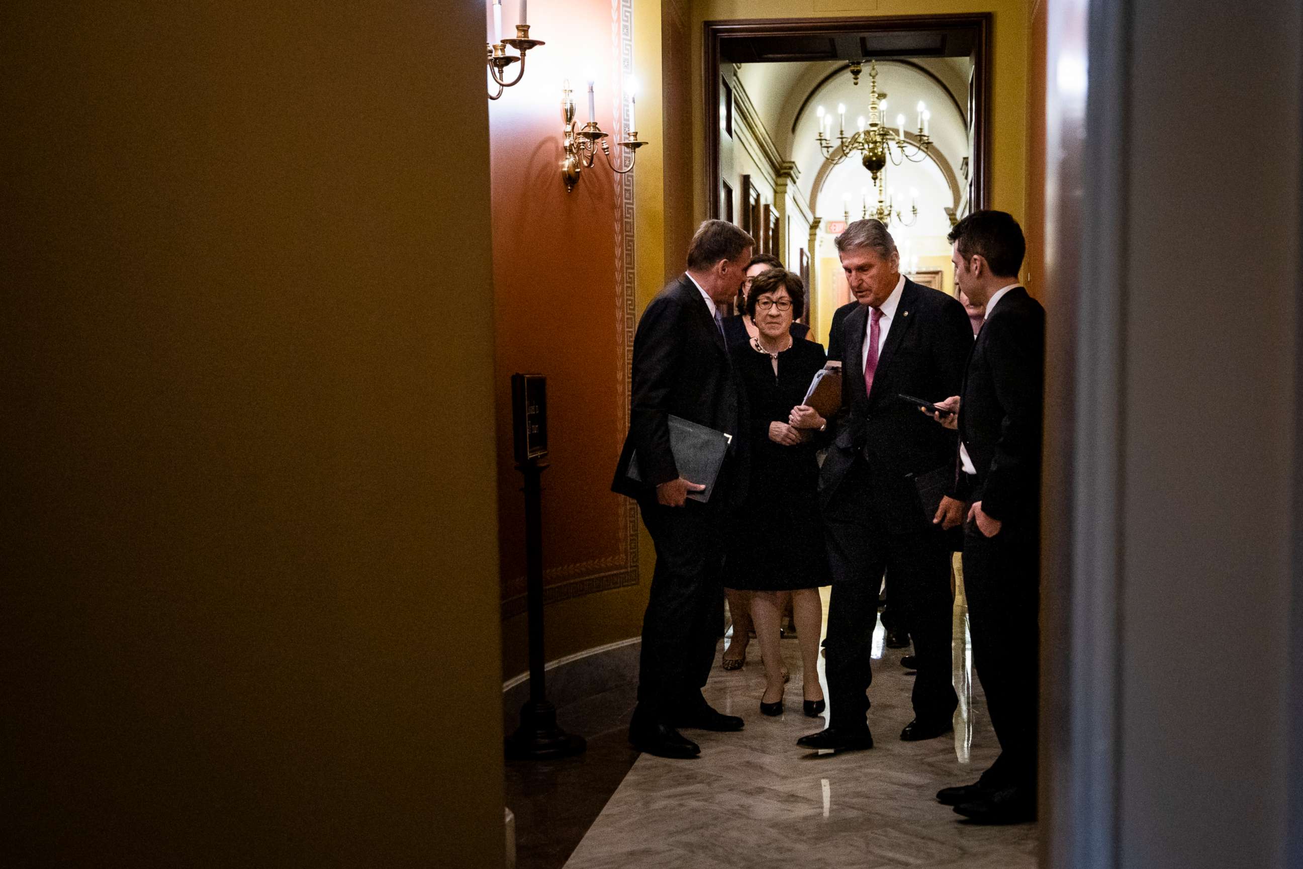 PHOTO: Sens. Mark Warner, D-Va., Susan Collins, R-Maine, and Joe Manchin, D-W.Va., talk as they leave a meeting between a bipartisan group of senators and White House officials as they negotiate an infrastructure plan on June 23, 2021.