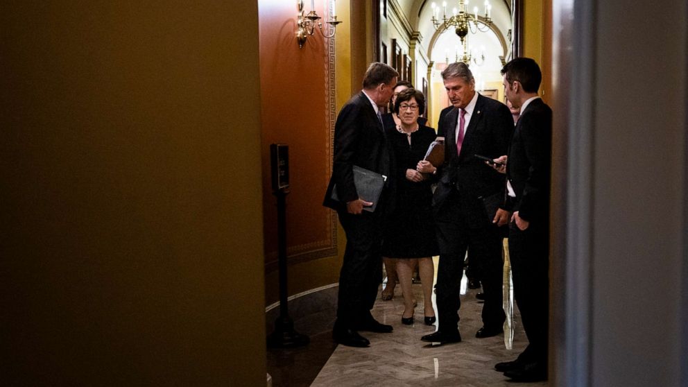 PHOTO: Sens. Mark Warner, D-Va., Susan Collins, R-Maine, and Joe Manchin, D-W.Va., talk as they leave a meeting between a bipartisan group of senators and White House officials as they negotiate an infrastructure plan on June 23, 2021.