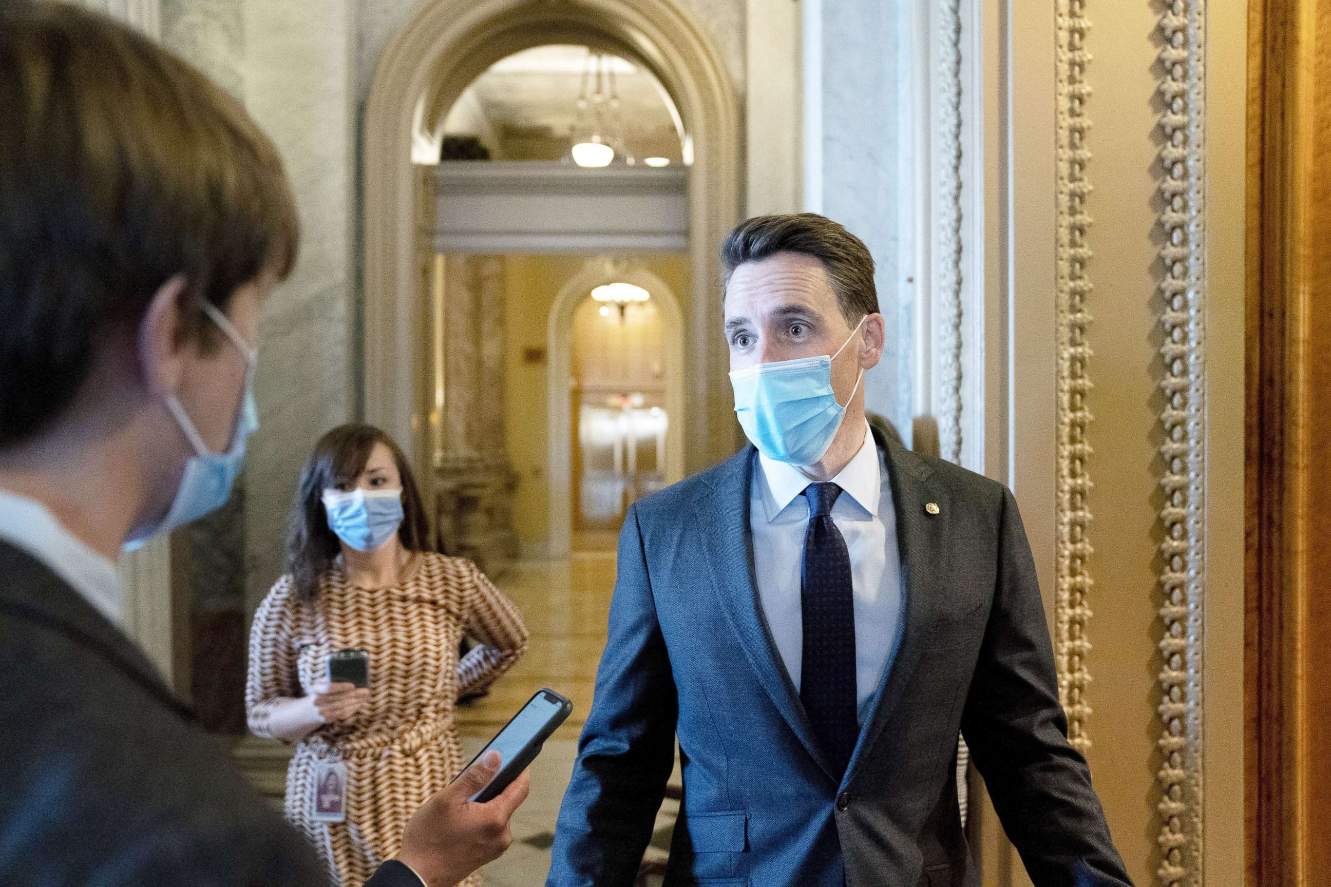 PHOTO: Sen. Josh Hawley wears a protective mask while speaking to reporters as he walks to the Senate Chamber in Washington, Jan. 22, 2021. 