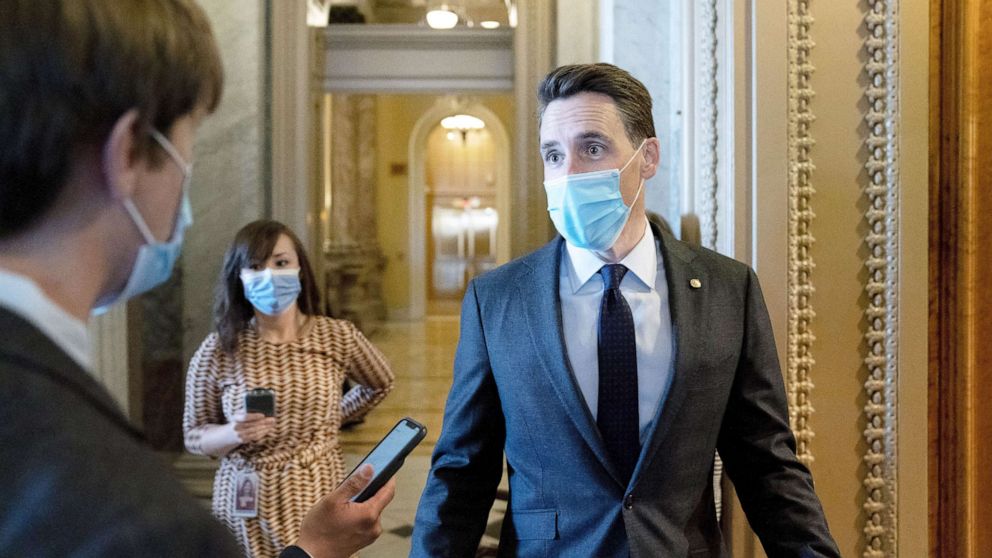 PHOTO: Sen. Josh Hawley wears a protective mask while speaking to reporters as he walks to the Senate Chamber in Washington, Jan. 22, 2021. 