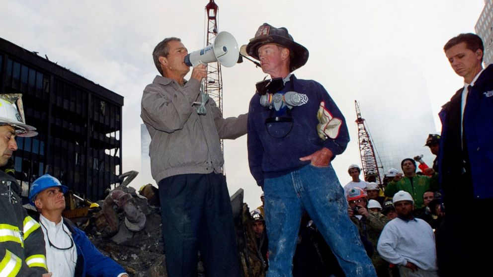 PHOTO: President Bush stands with firefighter Bob Beckwith on a burnt fire truck during a tour of the devastation as rescue efforts continue in the rubble of the World Trade Center in New York, Sept. 14, 2001.