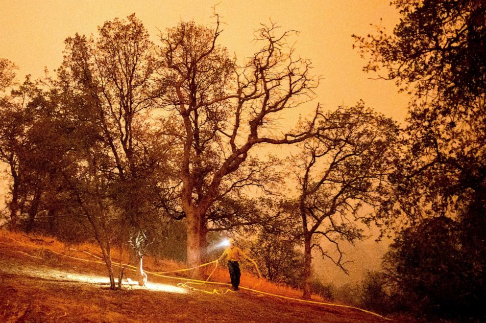 PHOTO: A firefighter lays hose around the Foothills Visitor Center while battling the KNP Complex Fire in Sequoia National Park, Calif., Sept. 14, 2021.