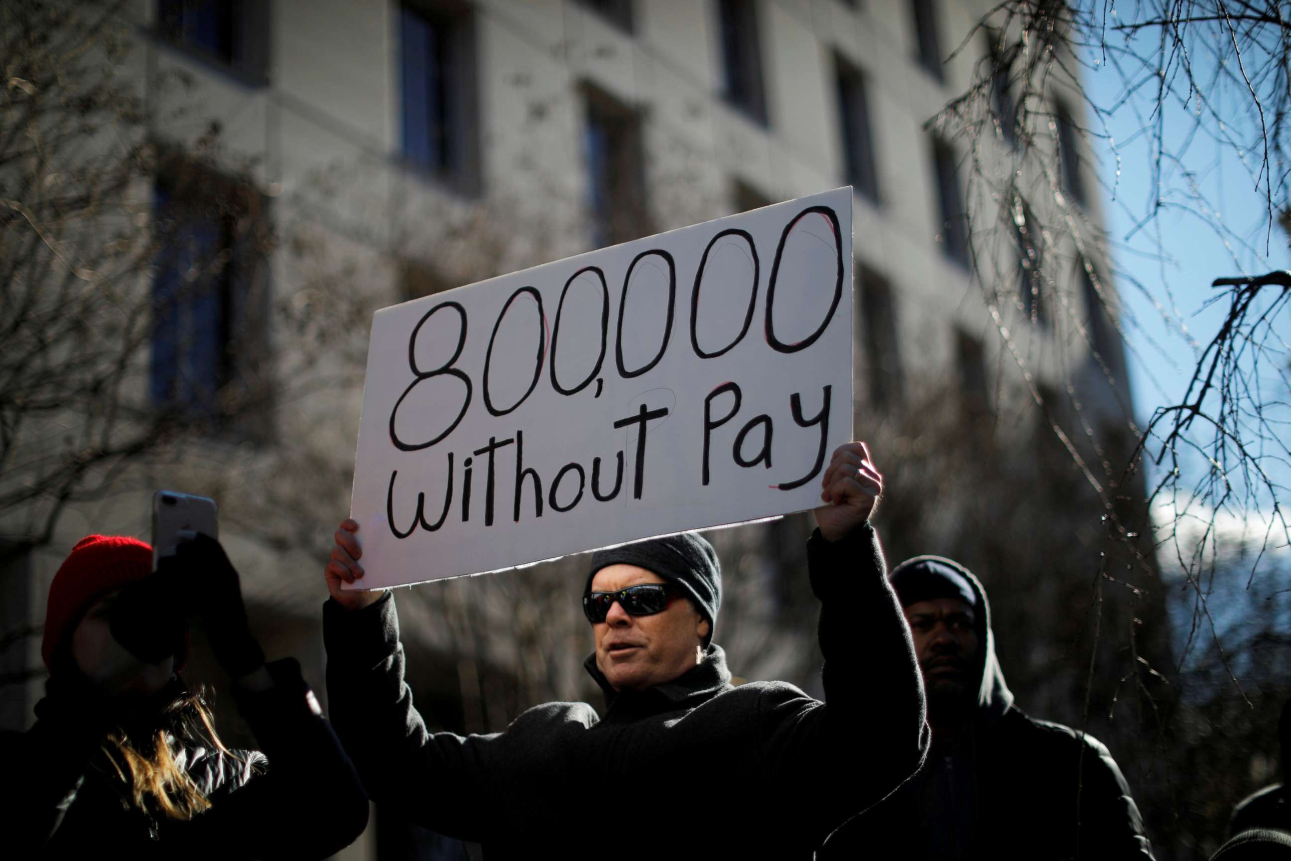 PHOTO: A demonstrator holds a sign, signifying hundreds of thousands of federal employees who will not be receiving their paychecks as a result of the partial government shutdown, during a rally to end the shutdown in Washington D.C., Jan. 10, 2019. 