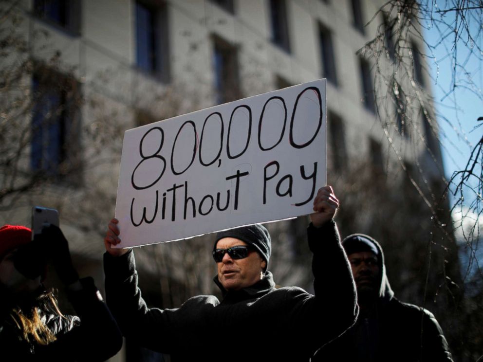 PHOTO: A demonstrator holds a sign, signifying hundreds of thousands of federal employees who will not be receiving their paychecks as a result of the partial government shutdown, during a rally to end the shutdown in Washington D.C., Jan. 10, 2019.