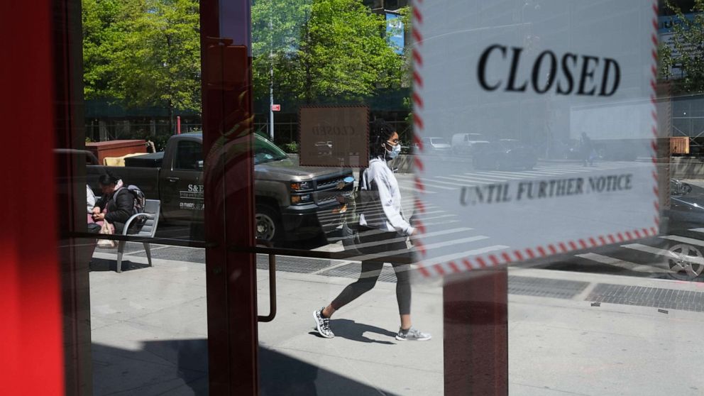 PHOTO: People walk through a shuttered business district in Brooklyn on May 12, 2020 in New York City.