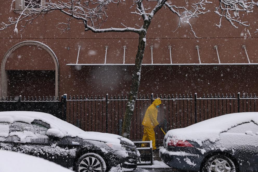 PHOTO: A person shovels the sidewalk as snow falls in the Brooklyn borough of New York City on Feb. 13, 2024. 