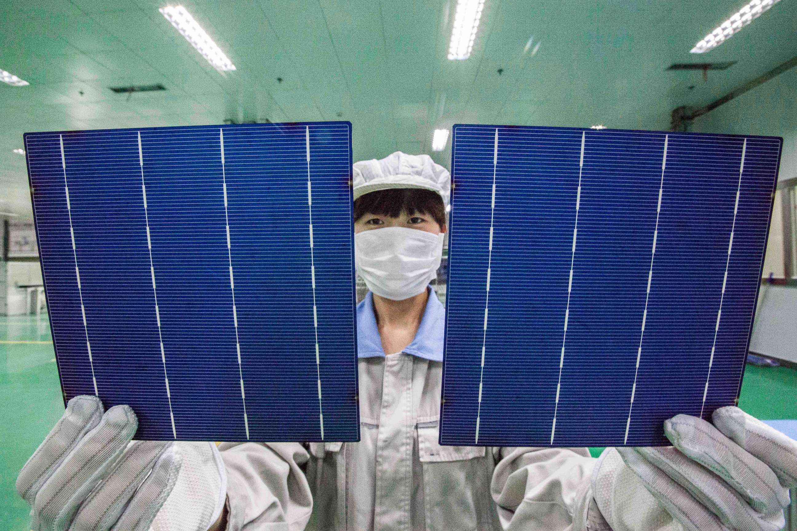 PHOTO: A Chinese worker shows photovoltaic cells to be used to make solar panels at a solar manufacturing plant in Lianyungang city, east Chinas Jiangsu province, China, Oct. 21, 2014.