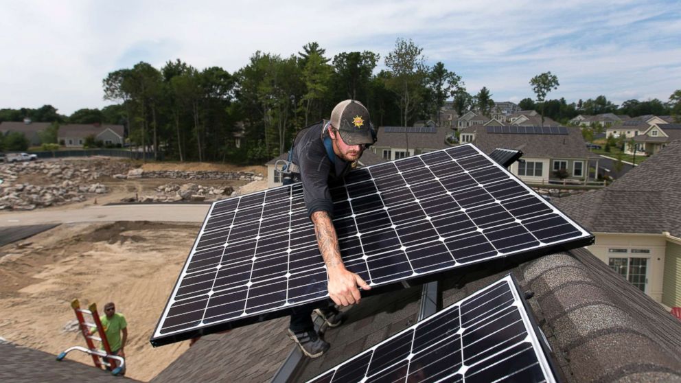 PHOTO: A man installs solar panels on a home in Falmouth, Maine, Aug. 2, 2017.