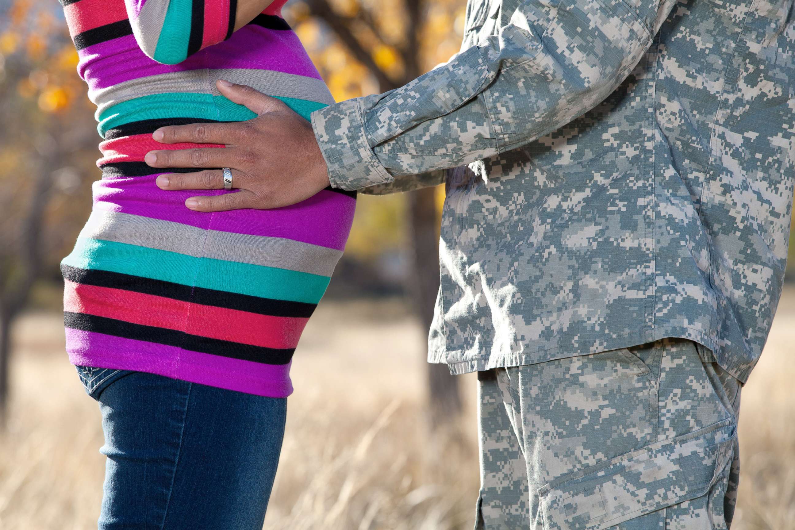 PHOTO: A stock photo of a soldier holding his pregnant partner's waist.
